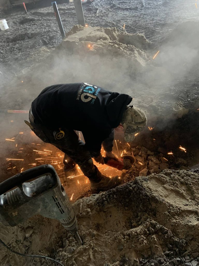Plombier professionnel effectuant une réparation de conduite souterraine avec chalumeau sur un chantier à Québec – service de plomberie d’urgence par Groupe JAB Plomberie Inc.